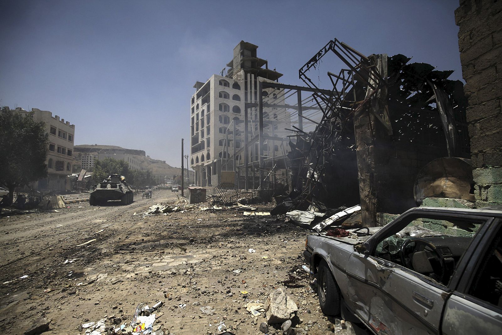 Smoke is seen at a damaged street, caused by an April 20 air strike that hit a nearby army weapons depot, in Sanaa