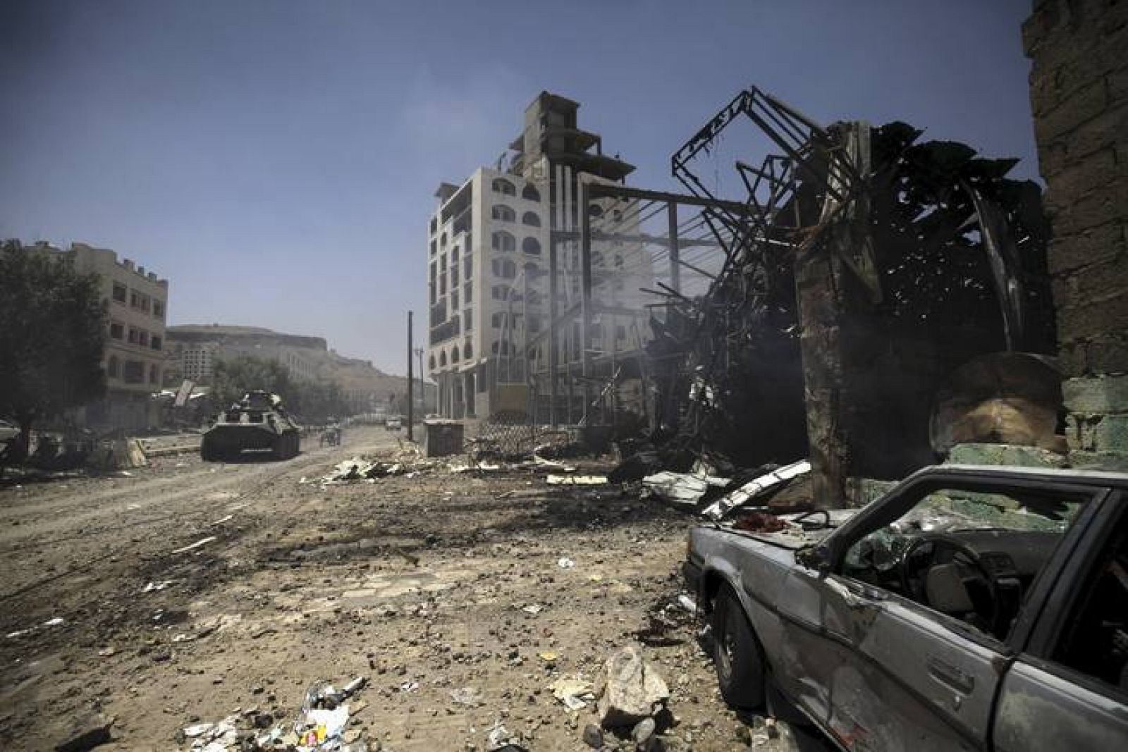 Smoke is seen at a damaged street, caused by an April 20 air strike that hit a nearby army weapons depot, in Sanaa