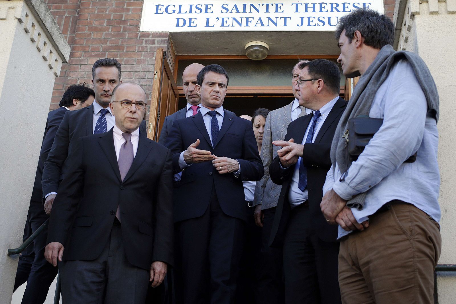 El primer ministro francés Manuel Valls (en el centro) y el ministro de Interior, Bernard Cazeneuve (izquierda) abandonan la iglesia de Villejuif, cerca de París, uno de los posibles objetivos terroristas