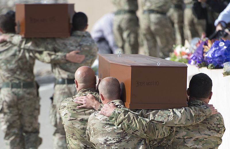 Militares transportan al hombro los ataúdes de 24 de los migrantes durante el funeral celebrado a las afueras de La Valeta (Malta)