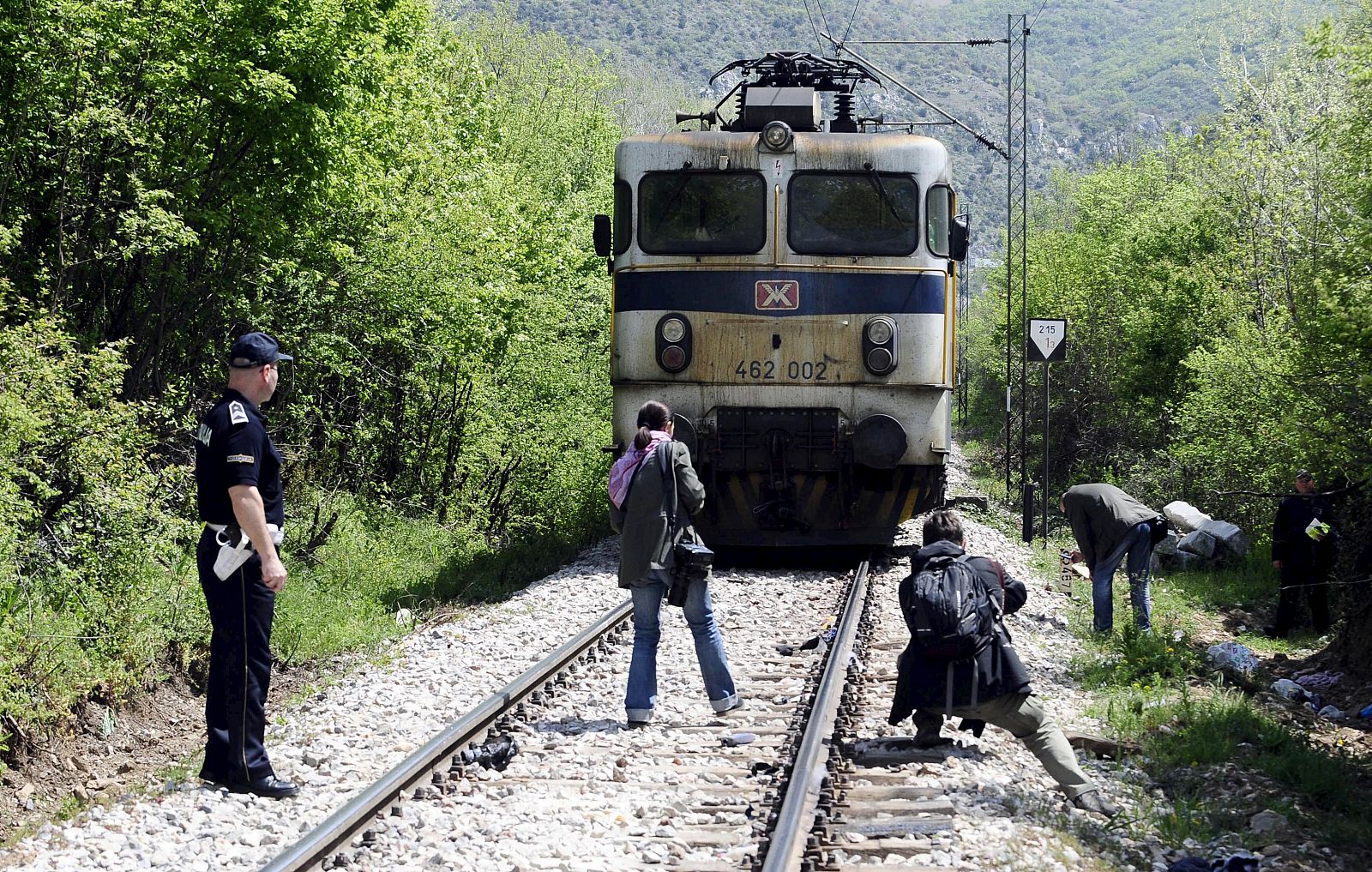 Media and police inspect at the scene where fourteen migrants were hit by a train, near Veles