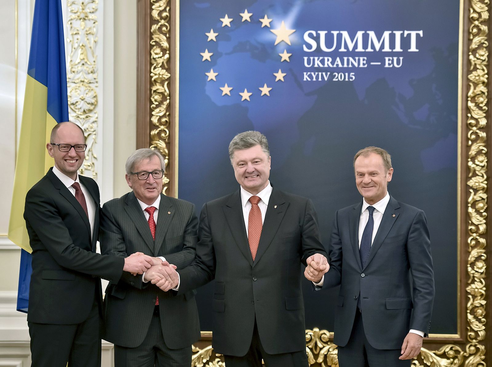 Los líderes de Ucrania y la UE, Yatseniuk, Juncker, Poroshenko y Tusk, entrelazan sus manos en la cumbre de este lunes.