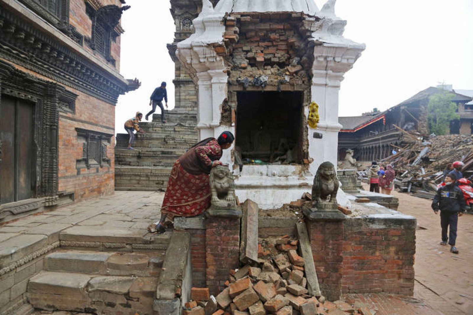  Una mujer inspecciona el interior de las ruinas de un templo destruido por el terremoto