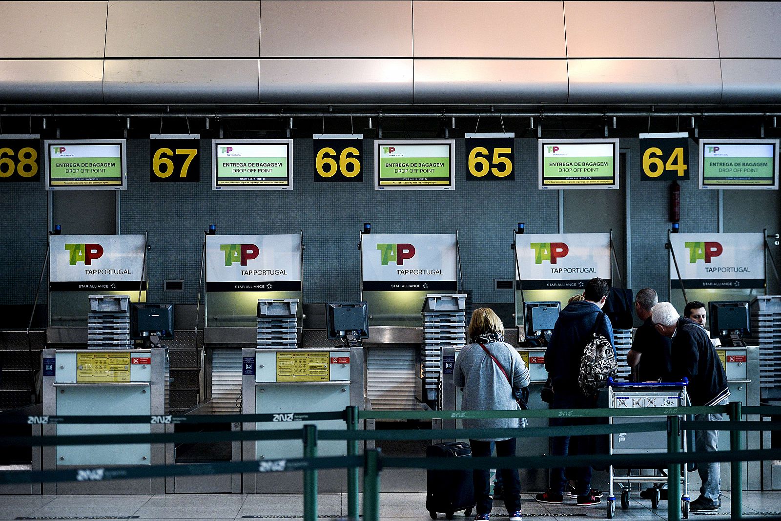 Varios pasajeros en el mostrador de facturación de la aerolínea TAP en el aeropuerto de Lisboa (Portugal).