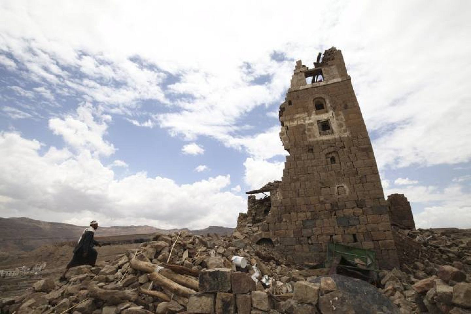 Man walks to a house that was damaged during an airstrike carried out by the Saudi-led coalition in Faj Attan village, Sanaa, Yemen