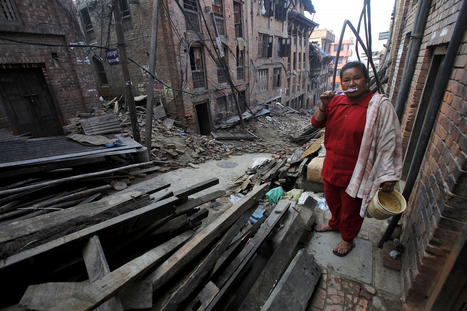 Una mujer nepalí junto a los escombros causados por el último terremoto en Bhaktapur