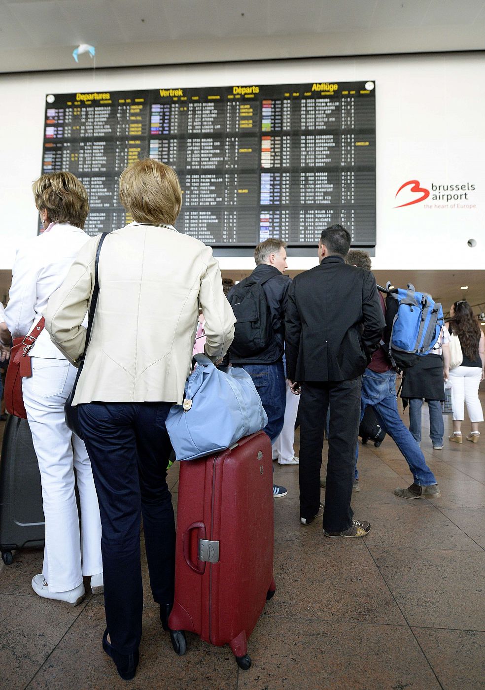 Pasajeros mirando los paneles de información del aeropuerto de Bruselas