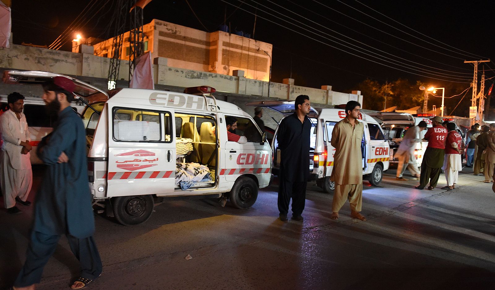 Habitantes de Quetta junto a una ambulancia que transportaba  cadáveres de los pasajeros del autobús asesinados a 40 kilómetros de la ciudad.