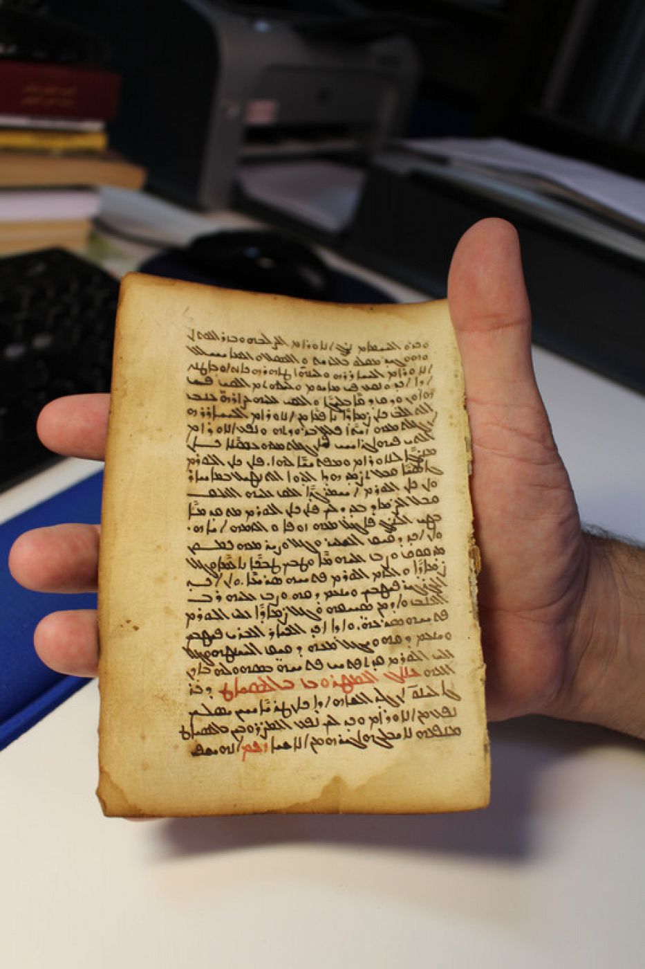 La hoja del códice con texto médico en manos del catedrático de la UCO Juan Pedro Monferre.