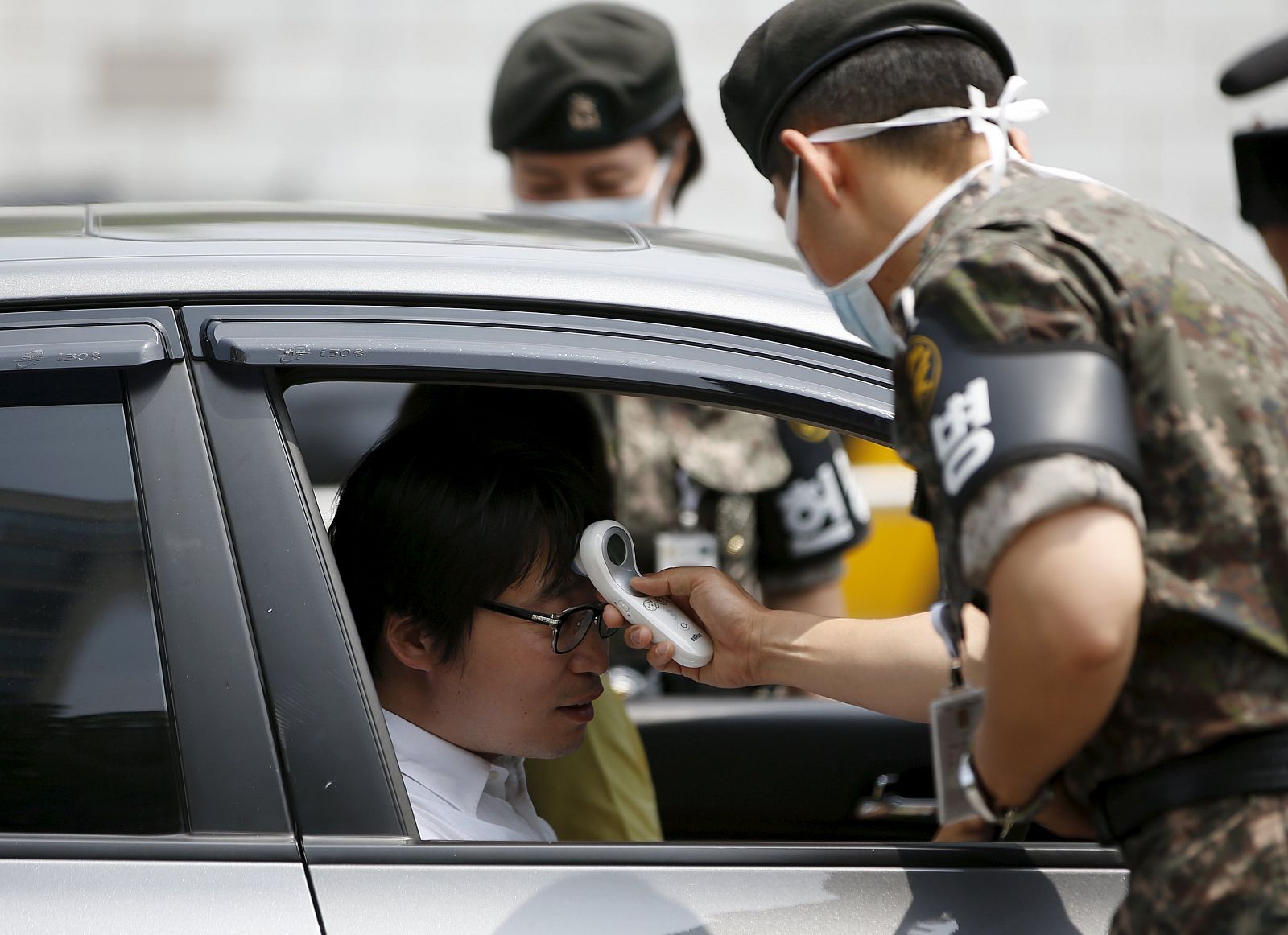 Militares toman la temperatura de un visitante en la puerta del Ministerio de Defensa en Seúl, Corea del Sur, en la campaña de alerta sanitaria por el MERS