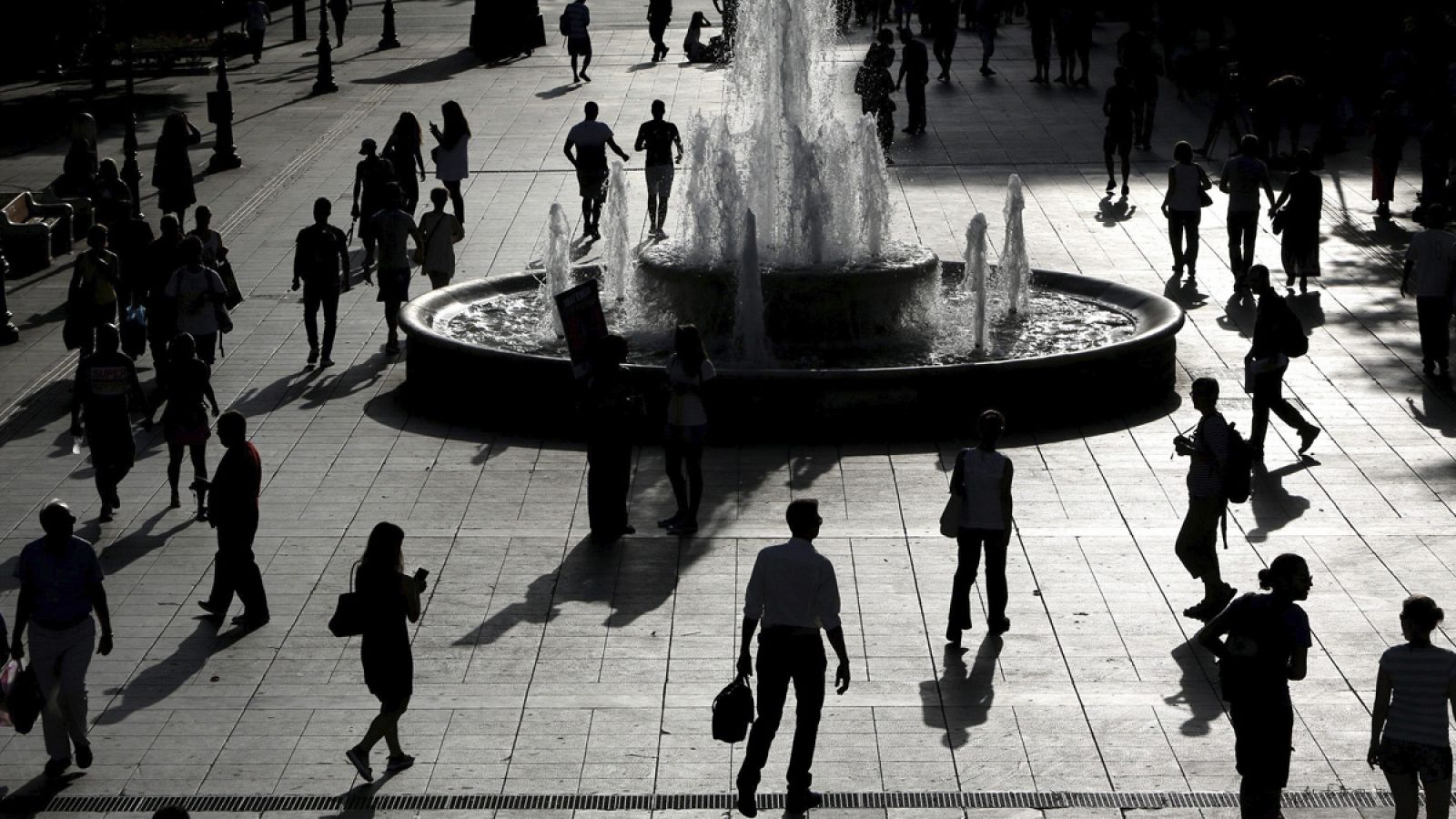 Vista de las siluetas de varias personas que pasean por la plaza Syntagma de Atenas