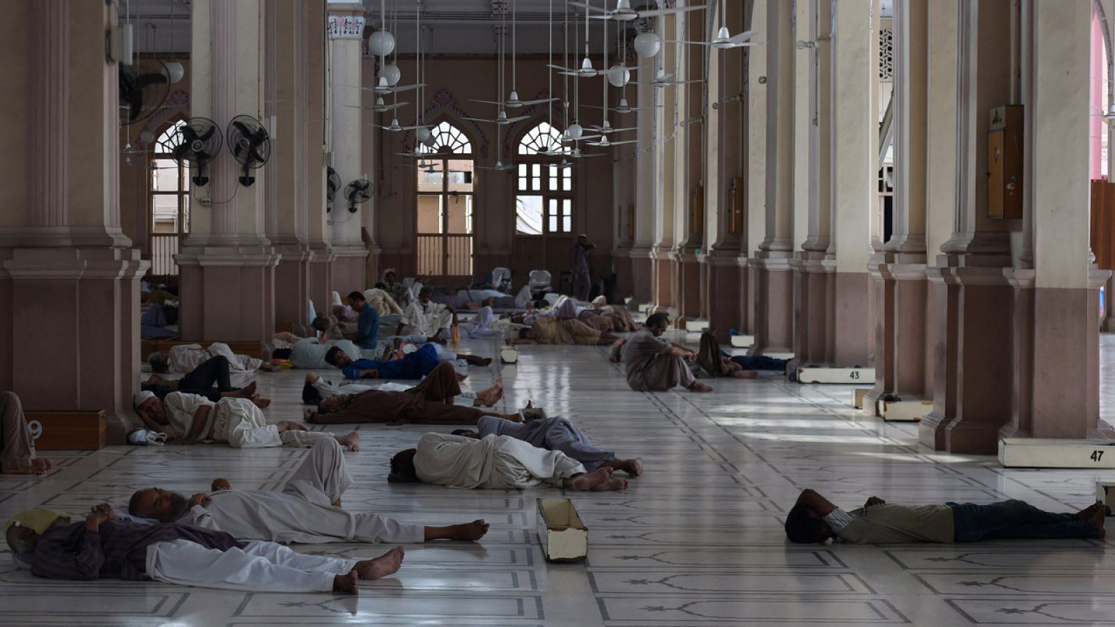 Hombres descansan y se refrescan en una mezquita de Karachi