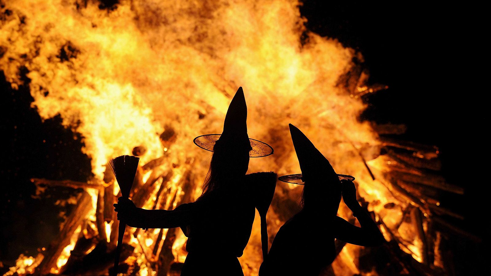 Dos mujeres disfrazadas de brujas celebran la noche de San Juan en Gijón.