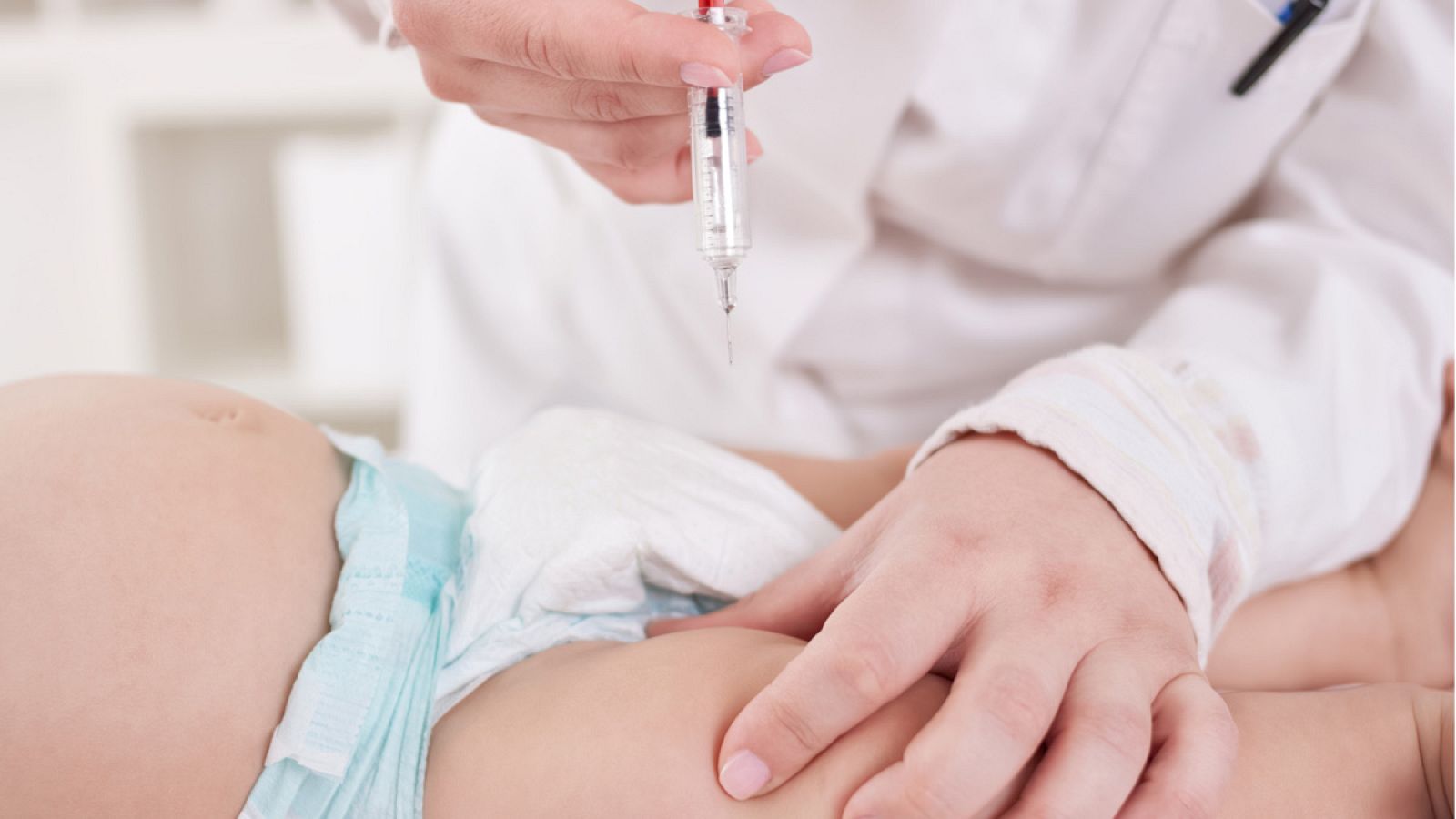 Un profesional sanitario vacunando a un bebé.