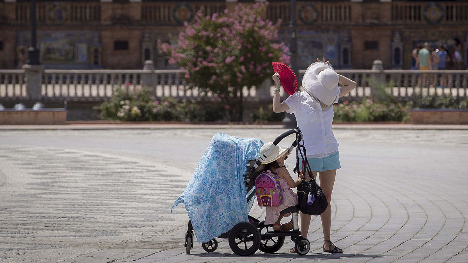 Una turista acompaUna turista acompañada de dos niños intenta aliviar el calor refrescándose con un abanico en Sevilla