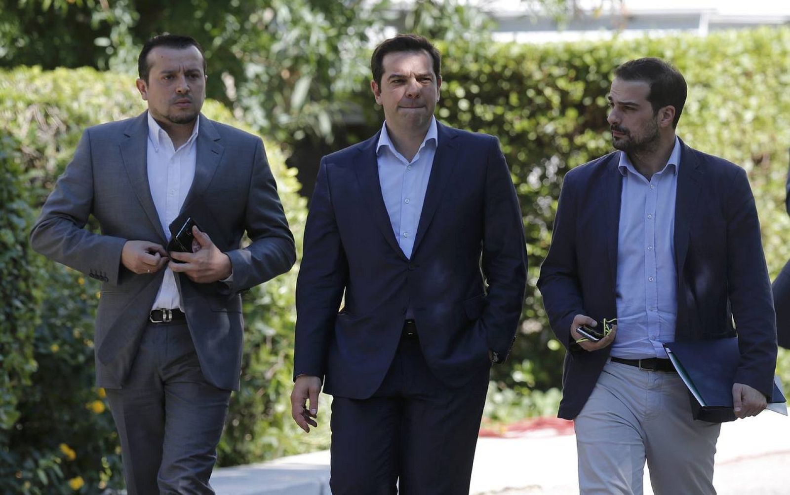 Greek Prime Minister Tsipras, Minister of State Papas and Government spokesman Sakelaridis leave the Presidential Palace for Maximos Mansion after a meeting with party leaders in central Athens