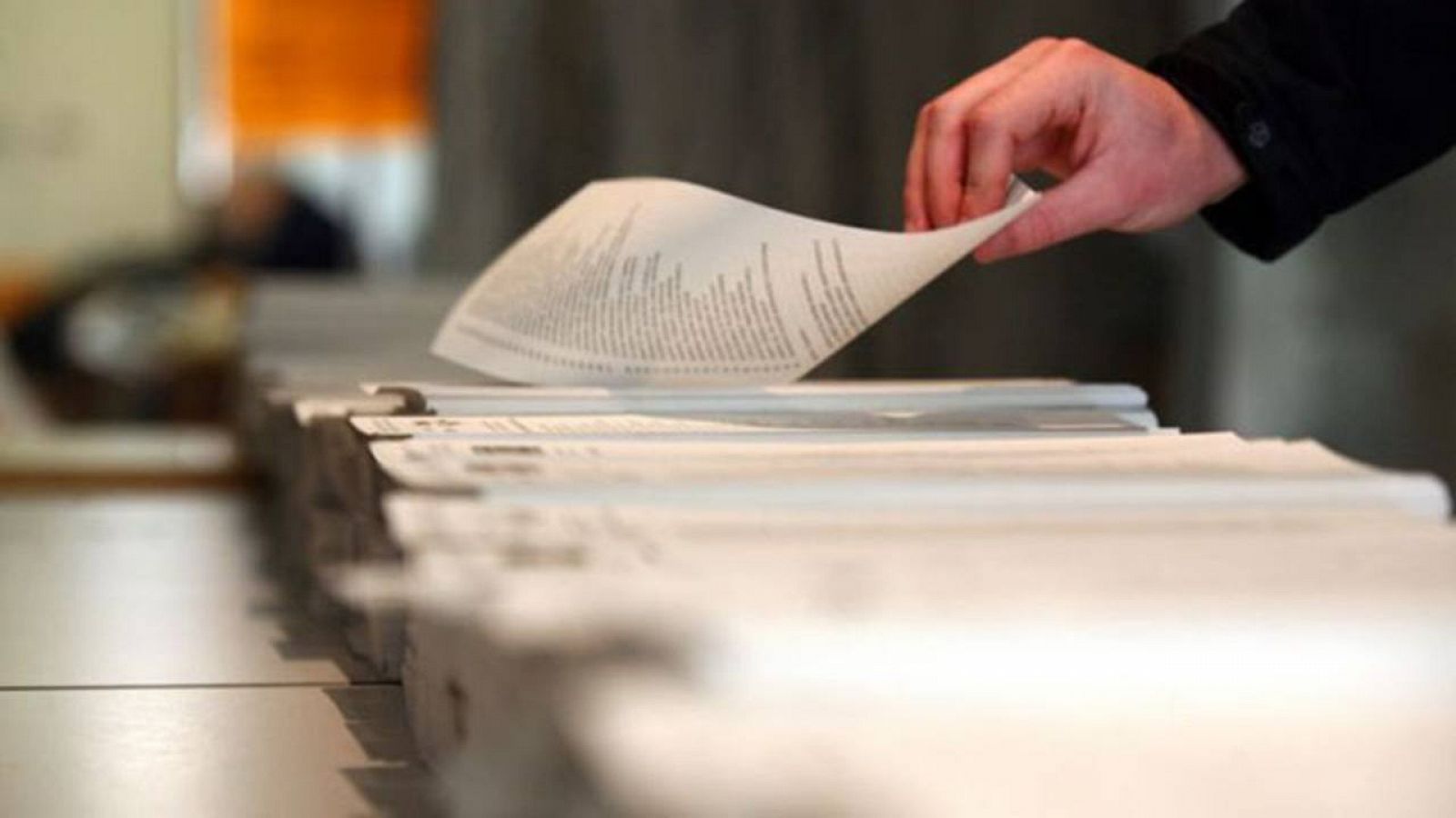 Un votante toma una papeleta en un colegio electoral.