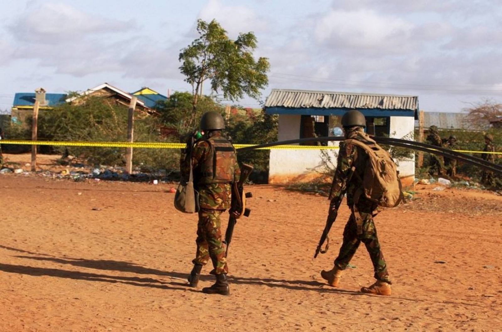 Kenya Defence Forces soldiers walk near the scene of an overnight attack on a residential complex in Mandera town at the Kenya-Somalia border