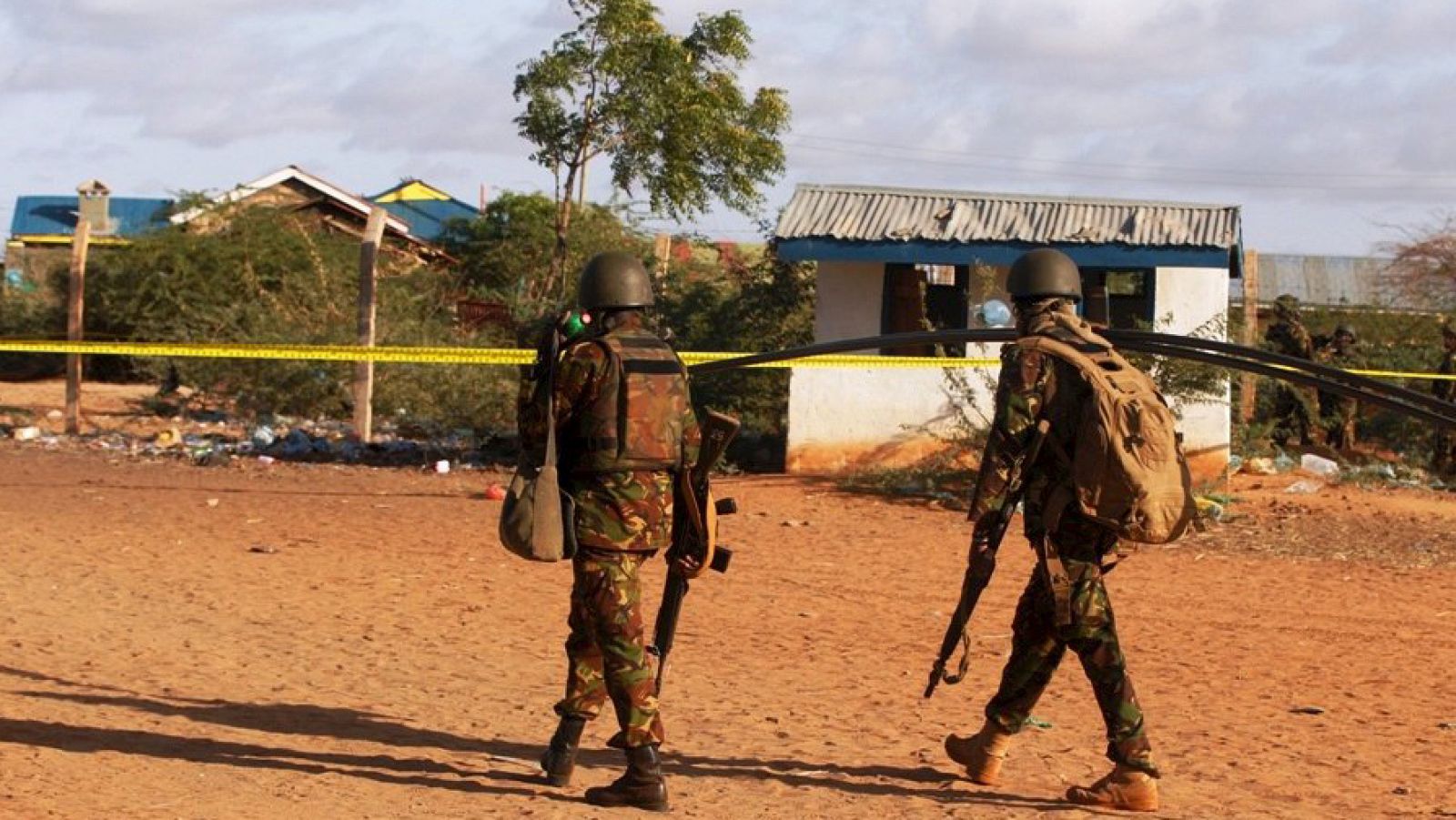 Kenya Defence Forces soldiers walk near the scene of an overnight attack on a residential complex in Mandera town at the Kenya-Somalia border