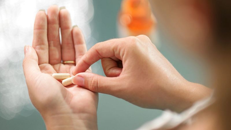 Imagen de archivo de una mujer consumiendo una pastilla.