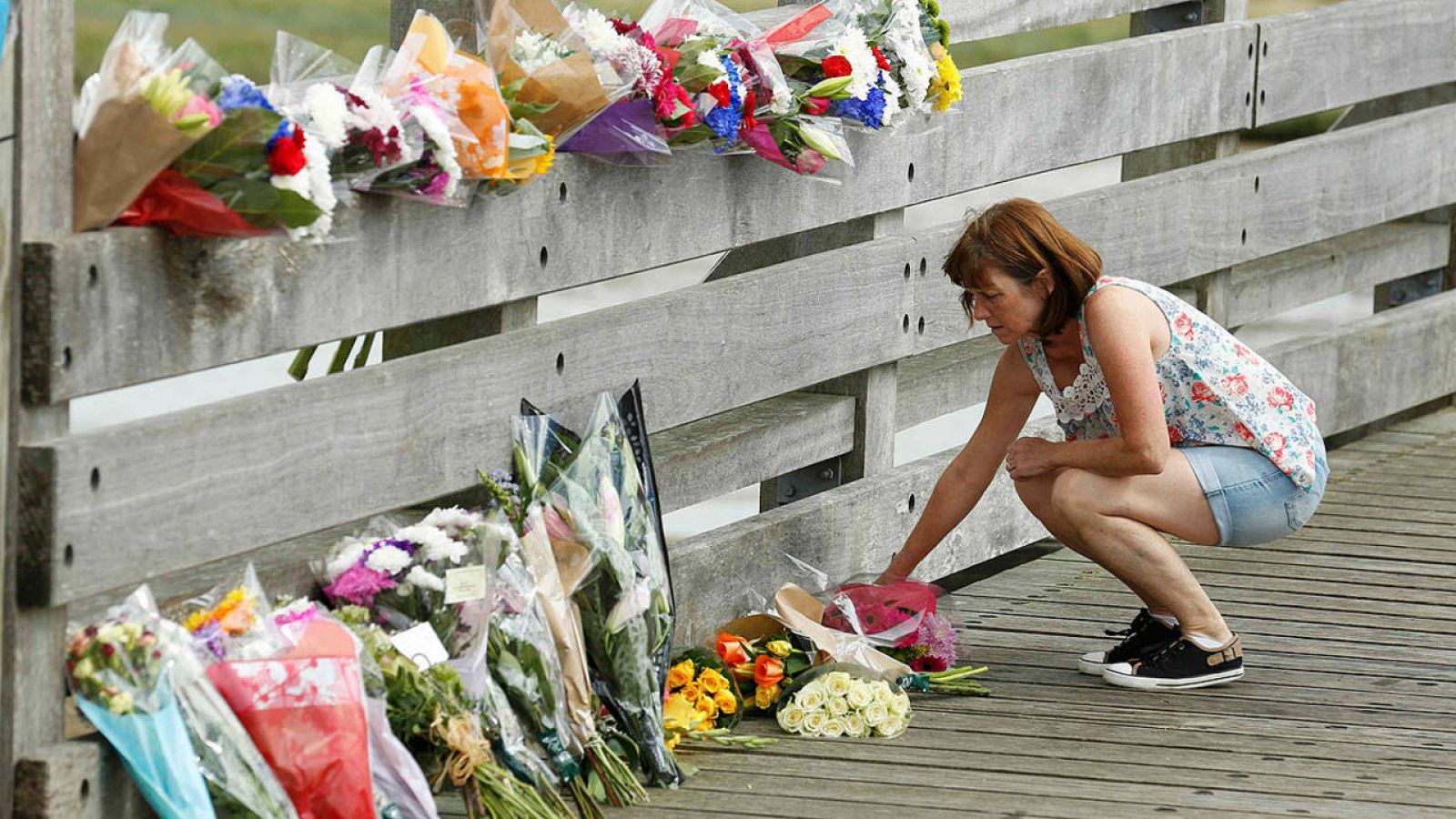 Una mujer deposita flores en Shoreham cerca del lugar del accidente