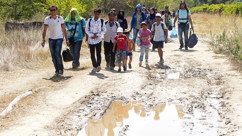 Un grupo de personas caminan entre Grecia y Macedonia este lunes.