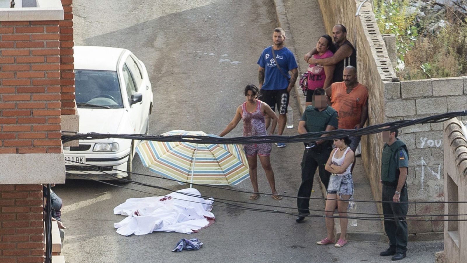 Agentes de la Guardia Civil y vecinos junto al cadáver de una mujer fallecida tras una reyerta multitudinaria en Mazarrón, Murcia.