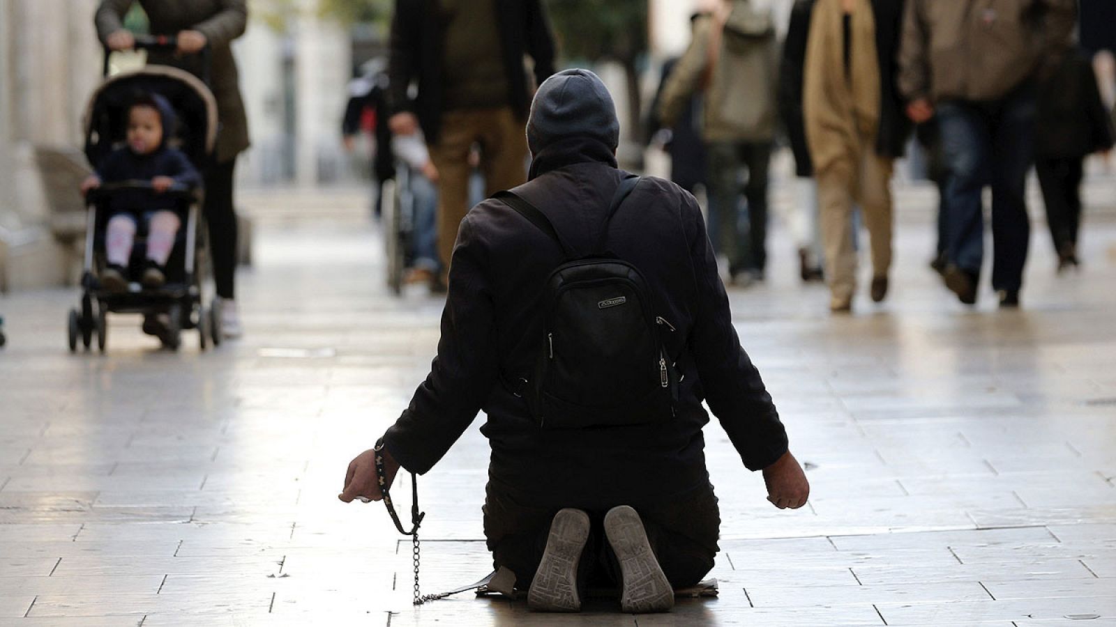 Un hombre pide limosna a las puertas del Mercado Central de Valencia