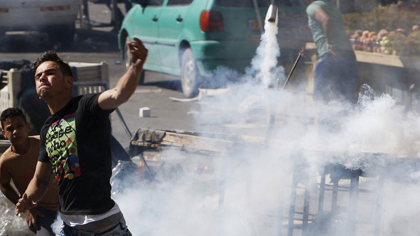 Un palestino devuelve un bote de gas a soldados israelíes