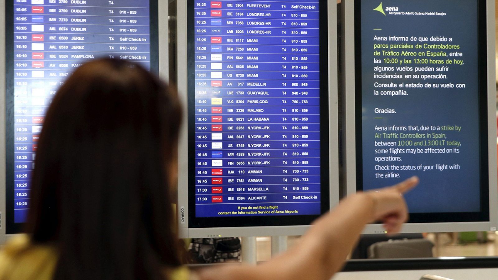 Una mujer mira el anuncio de los paros por la huelga en el aeropuerto de Barajas