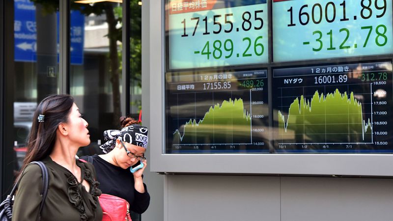 Dos japonesas pasan ante unos paneles bursátiles en Tokio
