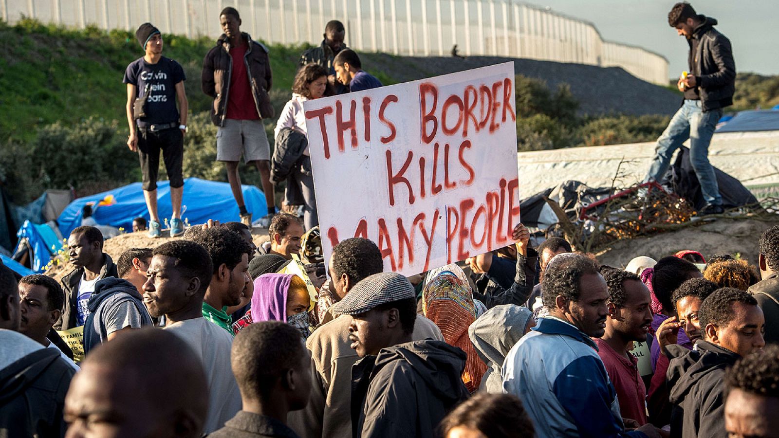 Cartel en el que se lee 'Esta frontera mata a mucha gente' durante una manifestación de migrantes en Calais, Francia.