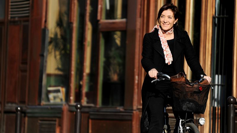 Una mujer de negocios pedaleando por las calles de París