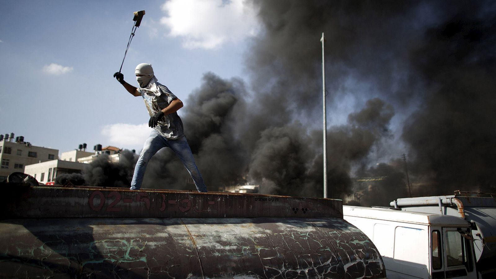 Un palestino usa una honda para lanzar piedras a los soldados israelíes en Beit El, cerca de Ramala, en Cisjordania