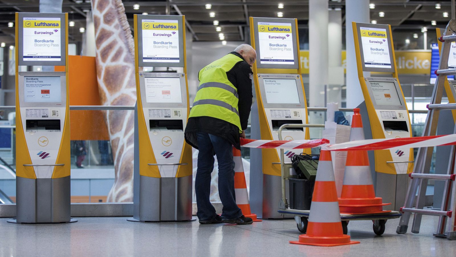 Un hombre acordona diversas máquinas de facturación en el aeropuerto de Düsseldorf