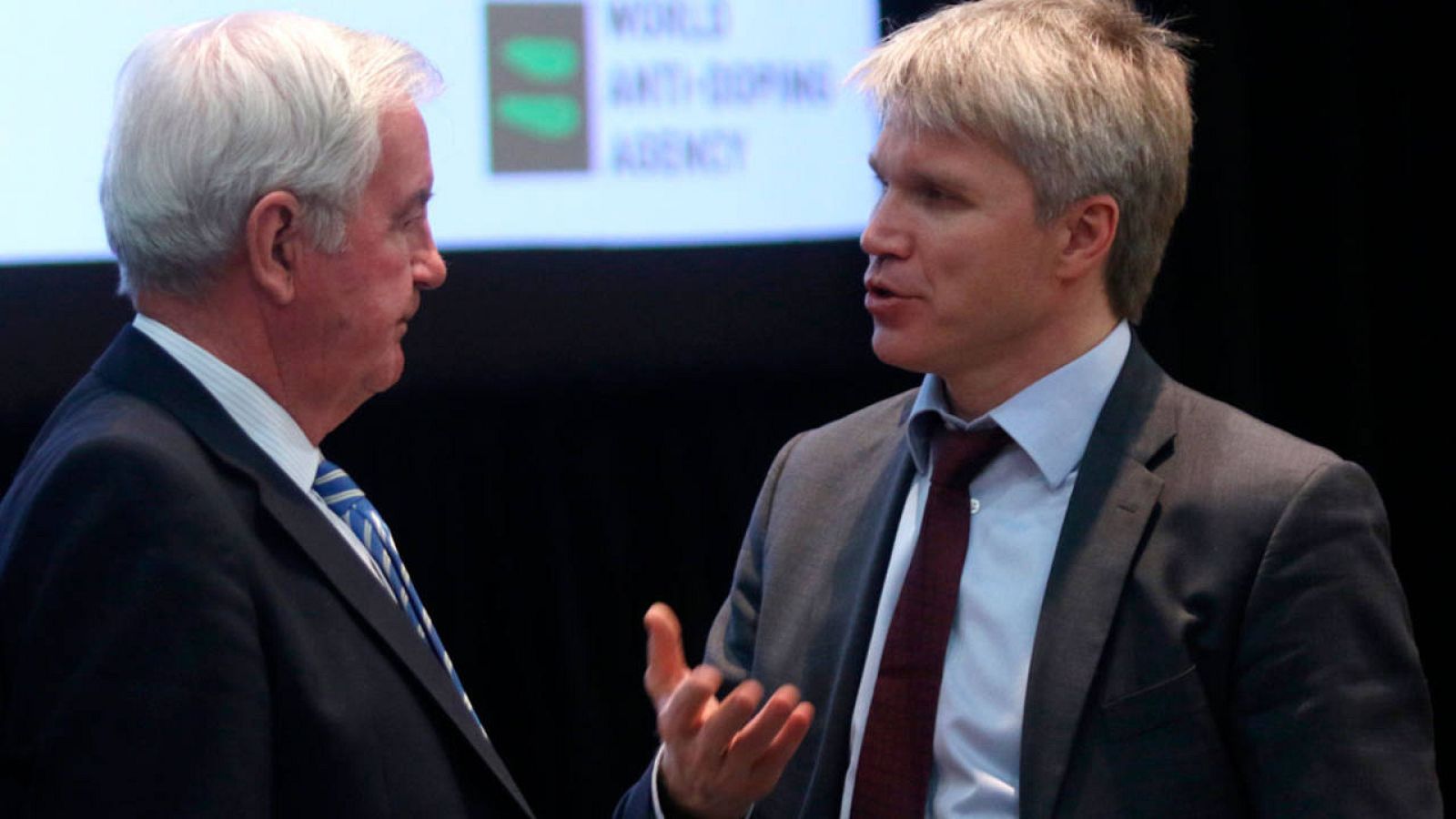 El presidente de la AMA, Sir Craig Reedie, charla con el subsecretario de Deportes ruso, Pavel Kolobkov.