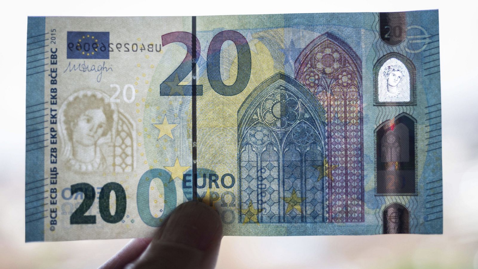 Un miembro del banco federal alemán muestra un nuevo billete de 20 euros durante su presentación en la sede del banco en Fráncfort
