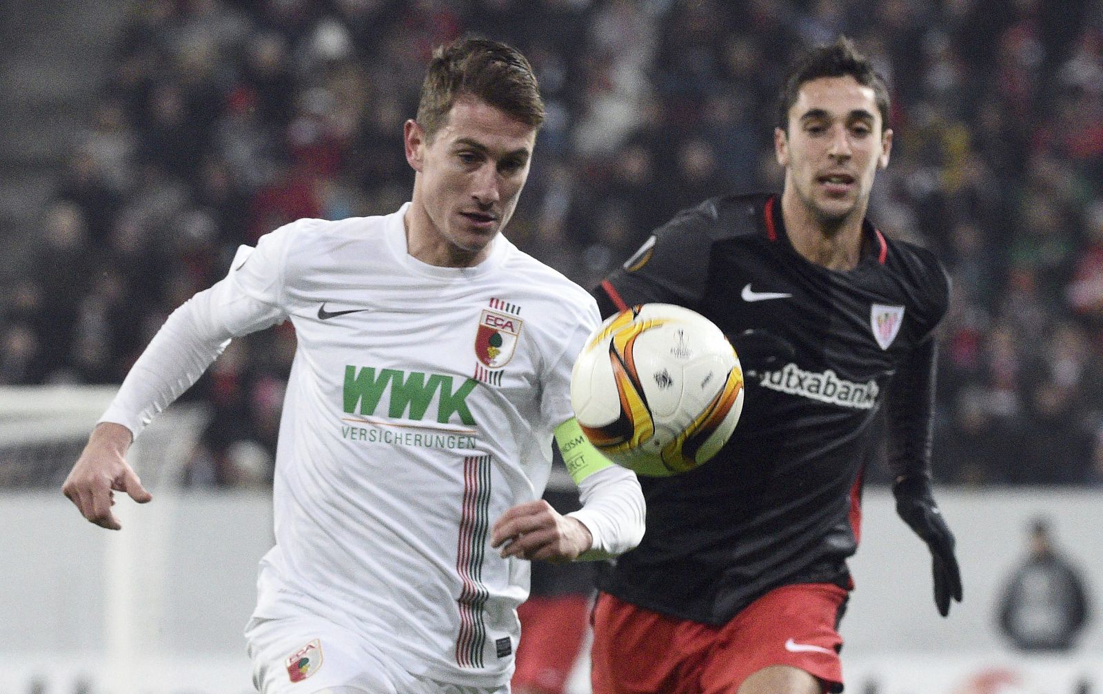 El jugador del Augsburgo, Paul Verhaegh lucha por el balón con Merino.