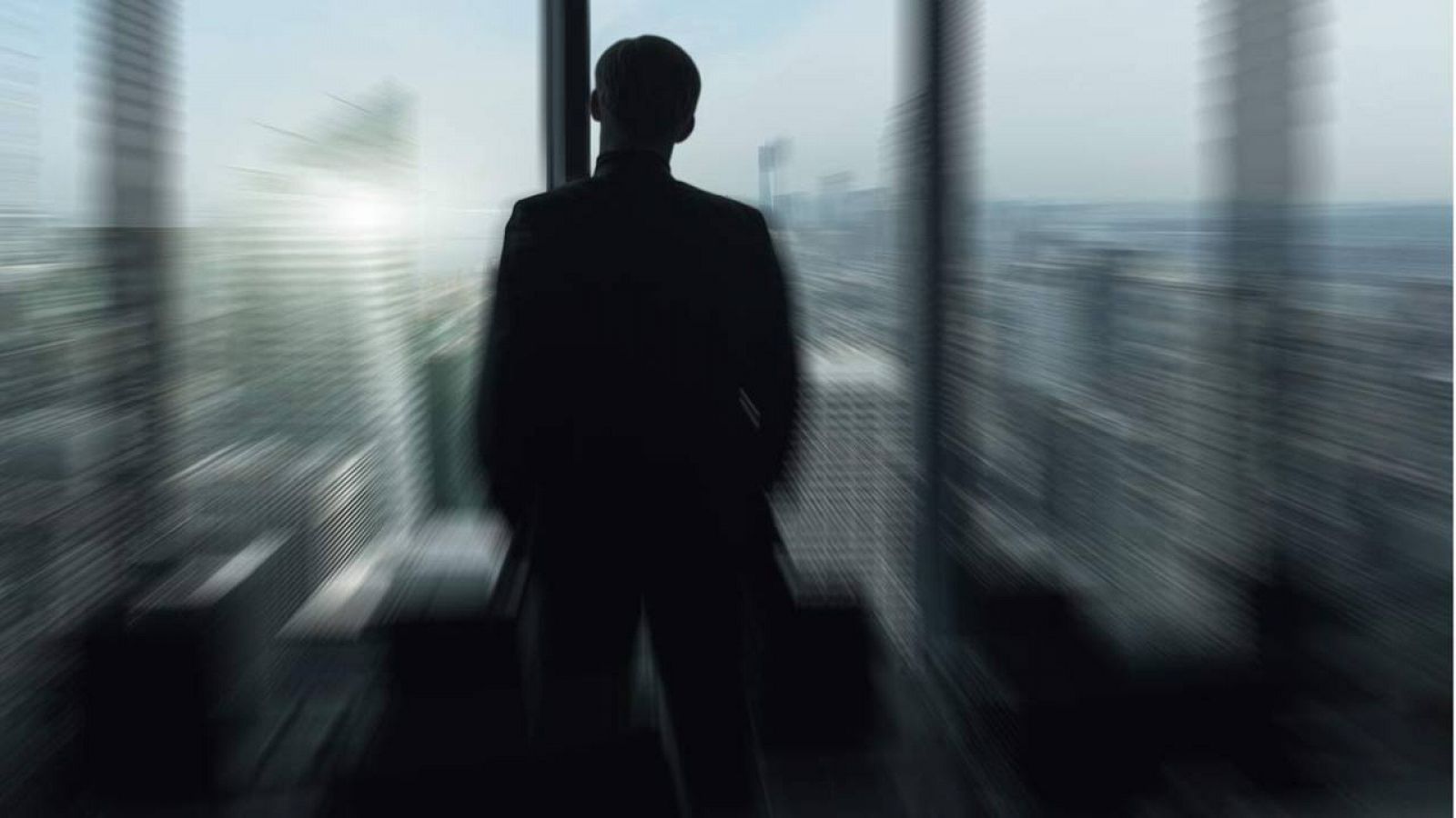 Imagen simbólica de un líder mirando a contraluz un horizonte urbano a través de una ventana.