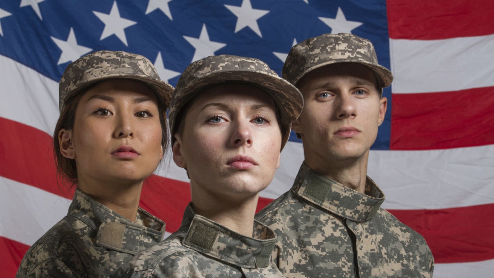 Tres soldados delante de la bandera de Estados Unidos
