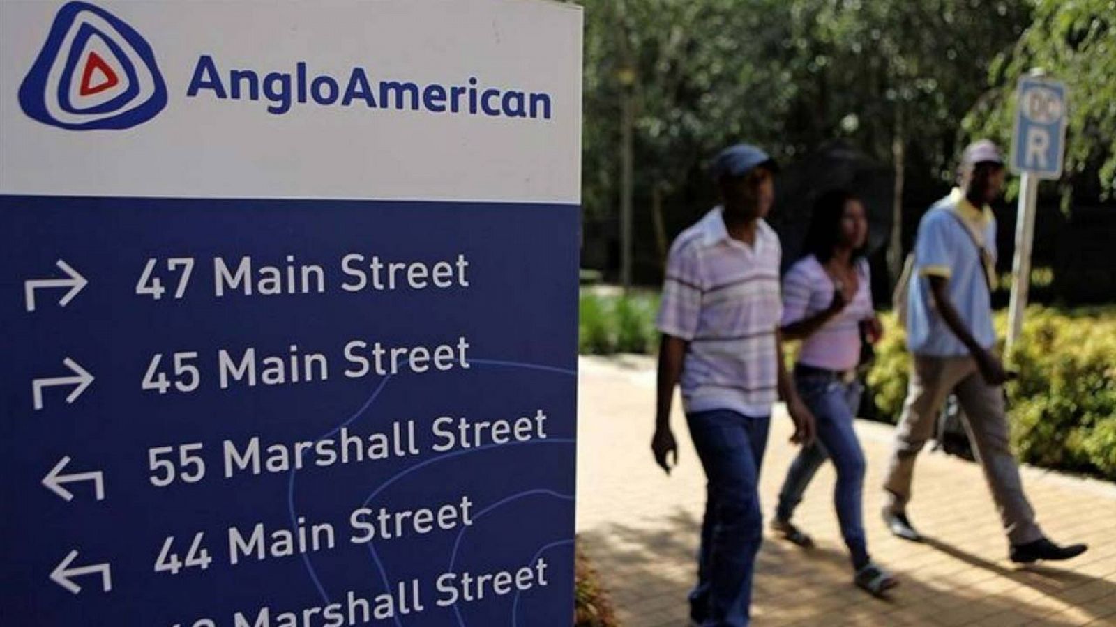 Viandantes pasan delante de la entrada de las oficinas de Anglo American en la capital de Sudáfrica, Johanesburgo