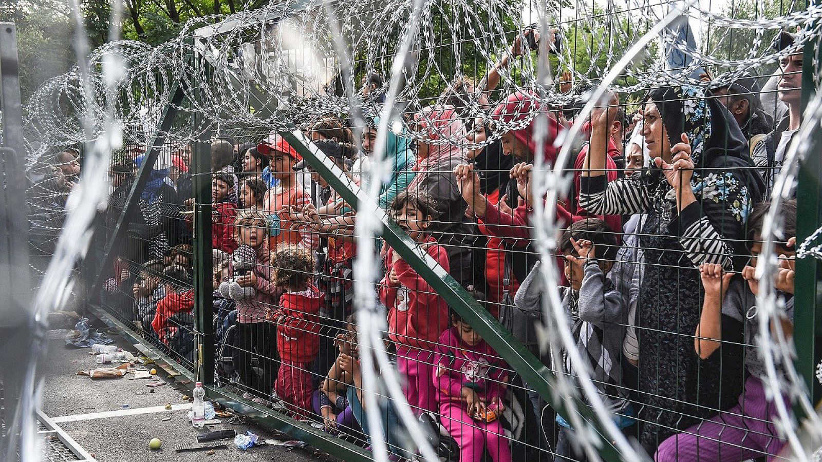 Refugiados tras una valla en la frontera de Hungría y Serbia, cerca de la ciudad de Horgos