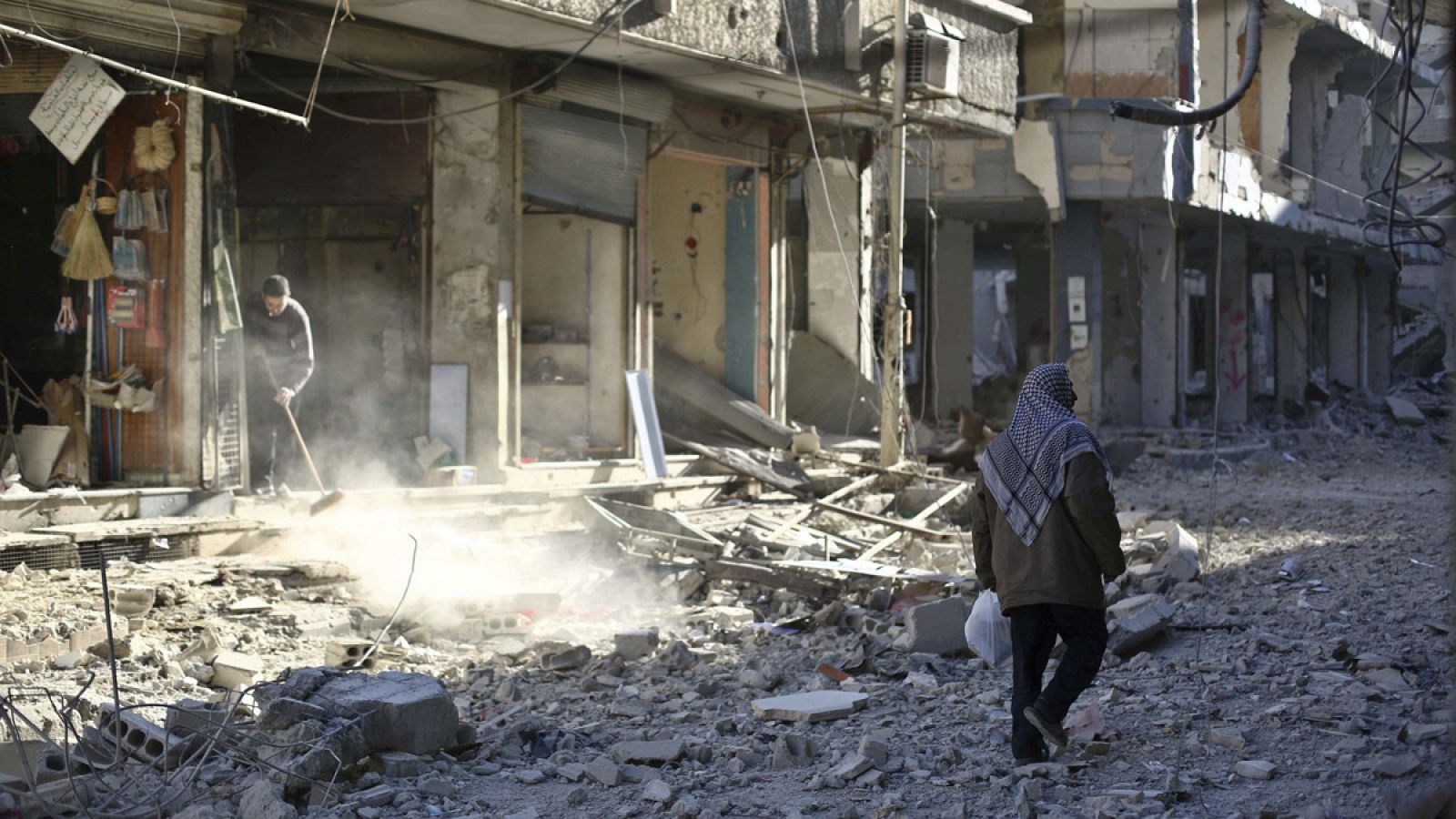Un hombre camina entre los escombros de un edificio en una calle de Douma, en las afueras de Damasco