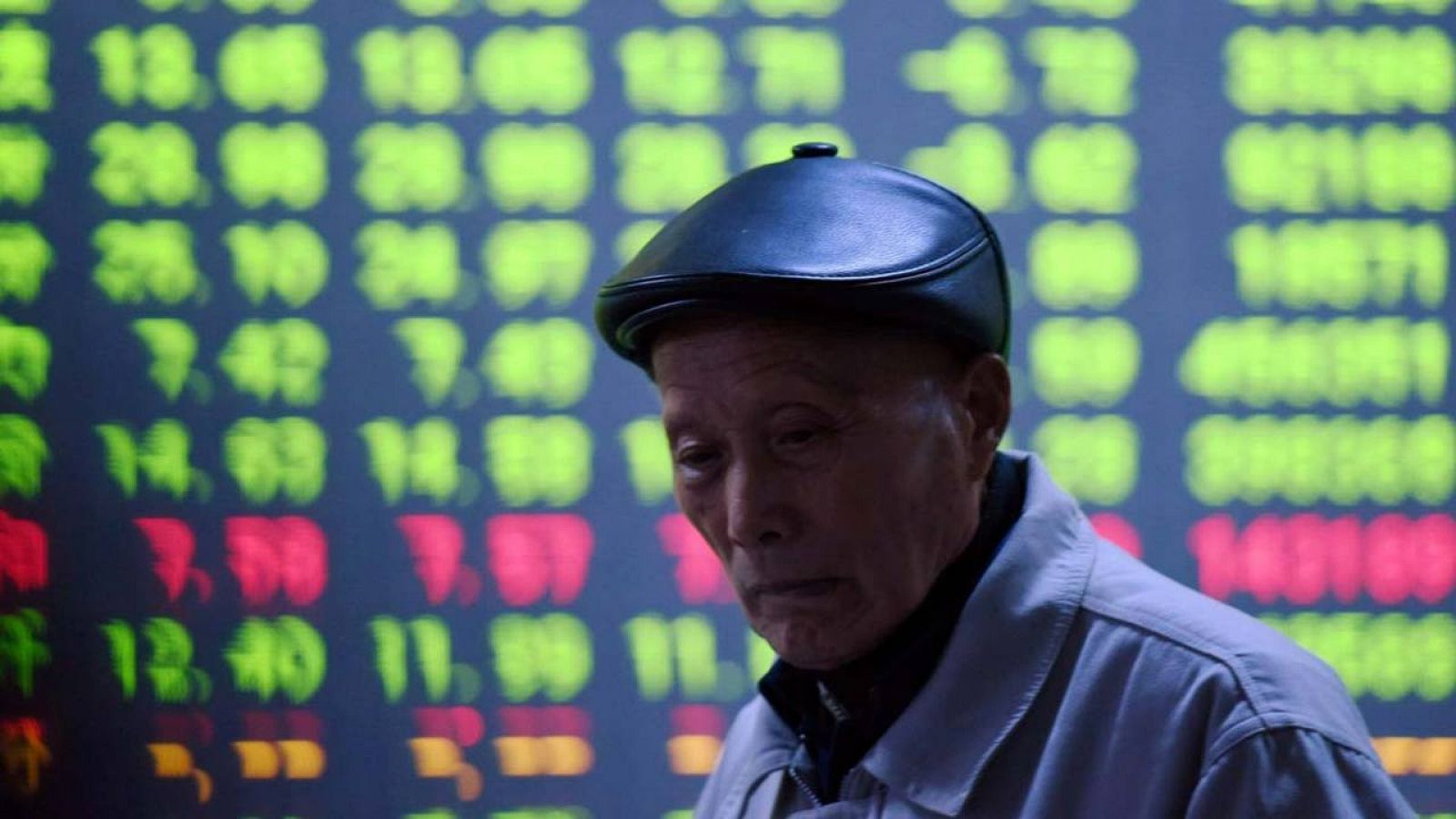 Un pequeño inversor, delante de una de las pantallas que muestra los movimientos de las Bolsas chinas en una asesoría bursátil de la ciudad de Hangzhou, en el este del país
