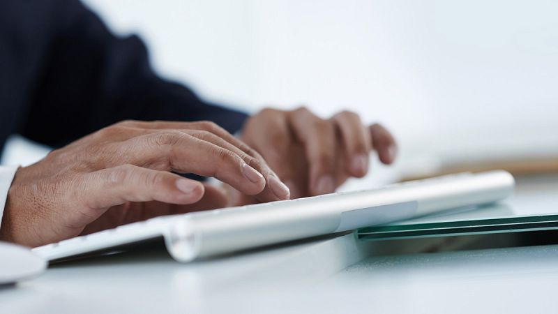 Una persona tecleando en un ordenador