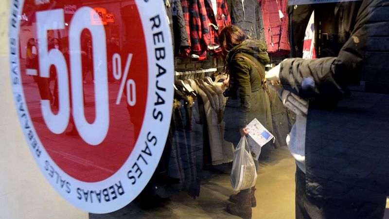 Una mujer mira ropa dentro de una tienda con rebajas en el centro de Madrid