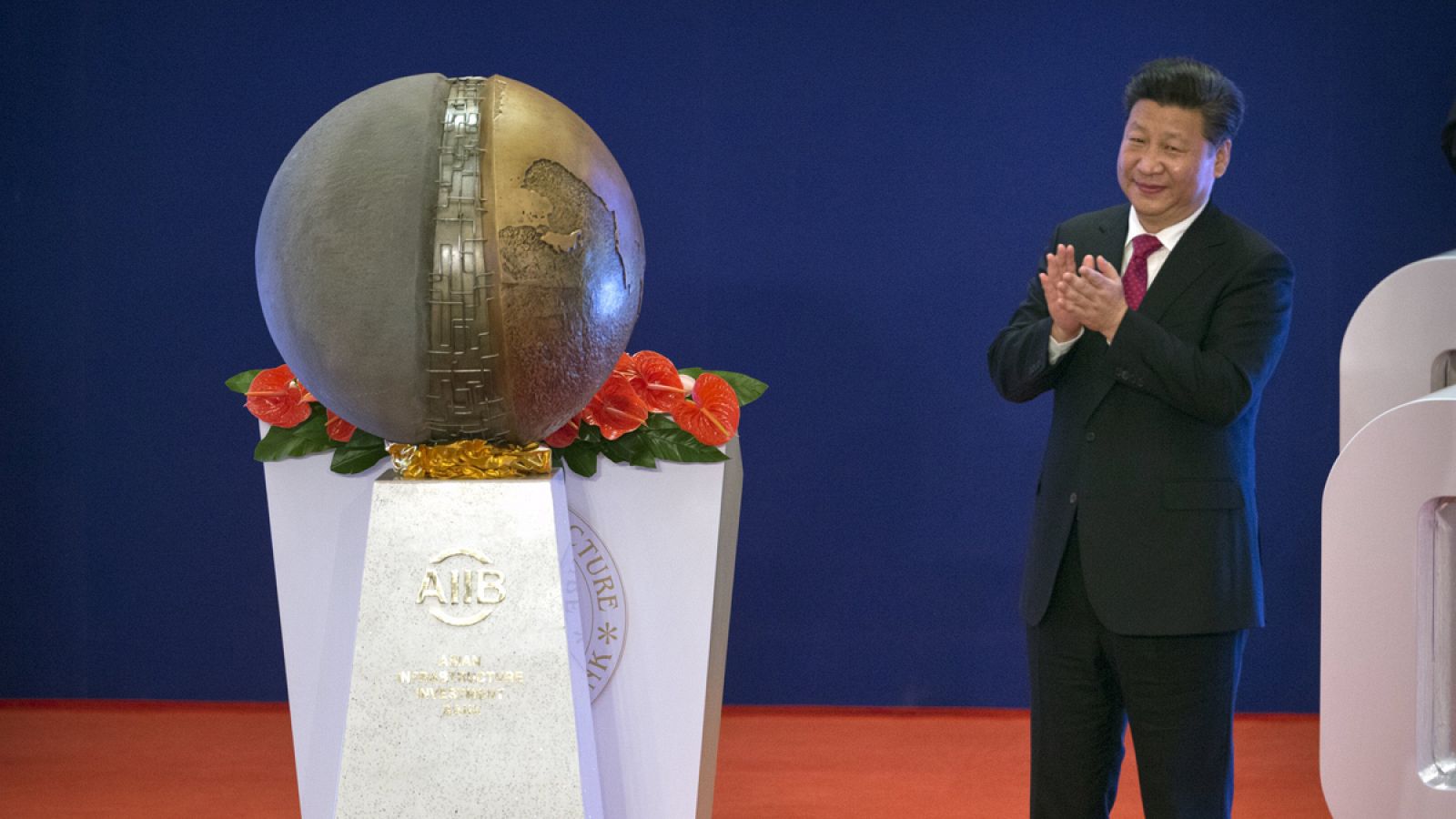 Chinese President Xi Jinping applauds after unveiling a sculpture during the opening ceremony of the Asian Infrastructure Investment Bank (AIIB) in Beijing