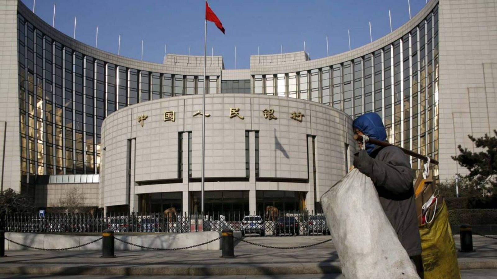 Un transeúnte pasa por delante de la sede del banco central chino en Pekín