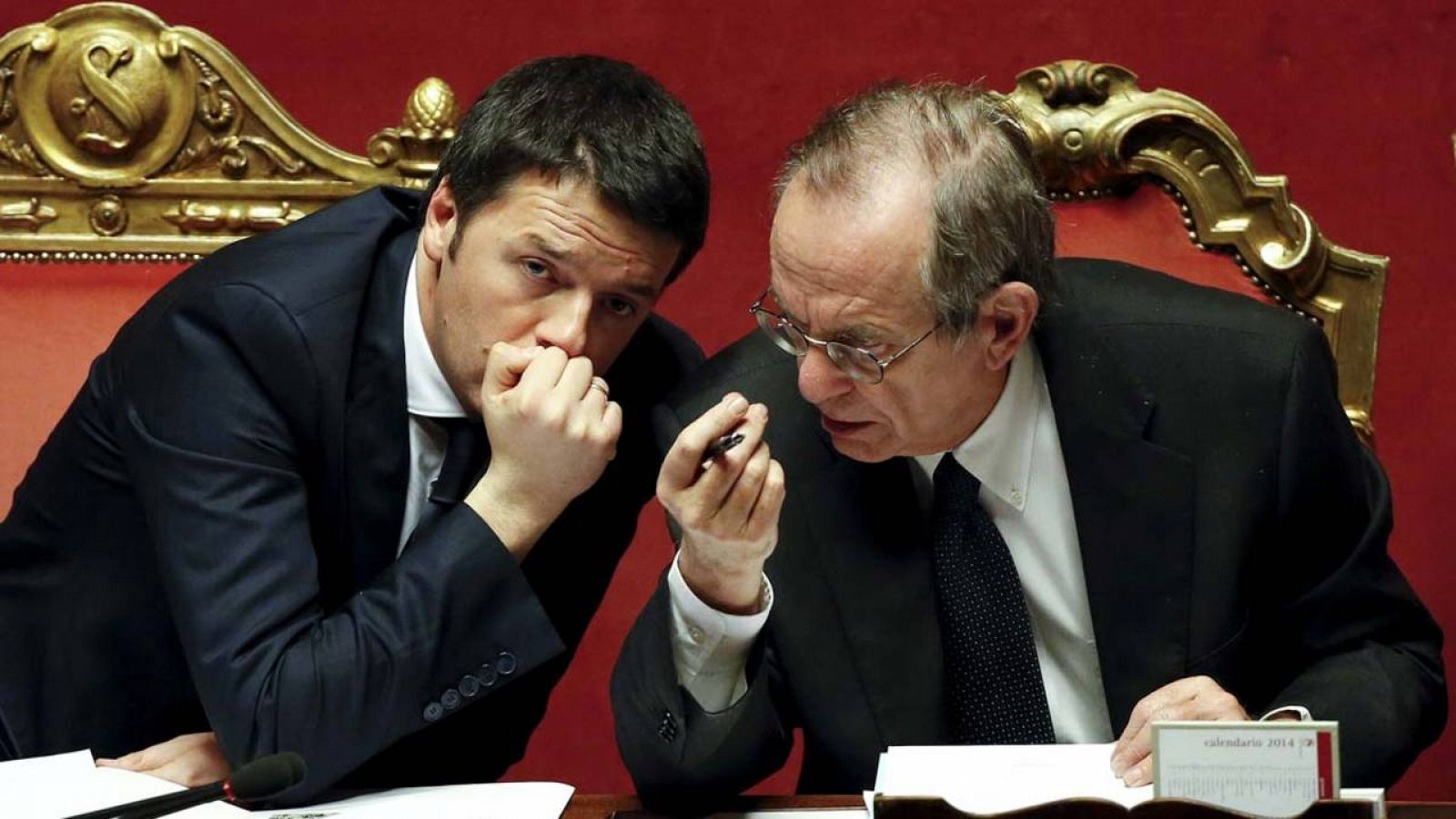 El primer ministro italiano, Matteo Renzi, habla con su ministro de Finanzas, Pier Carlo Padoan, durante un pleno del Senado
