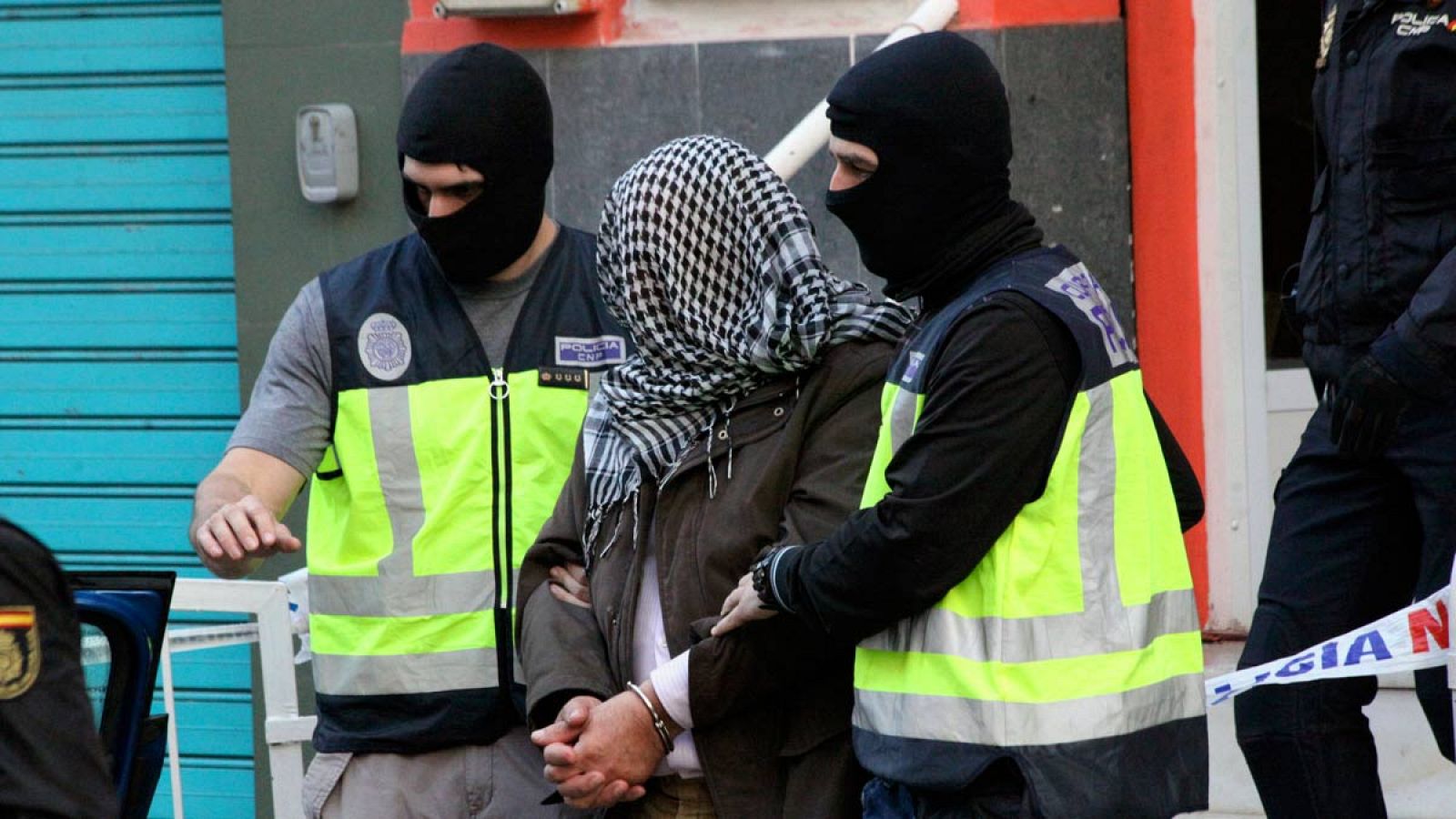 La policía traslada a uno de los detenidos en Ceuta por su por su presunta relación con las organizaciones terroristas Jabhat al Nusra y Daesh.
